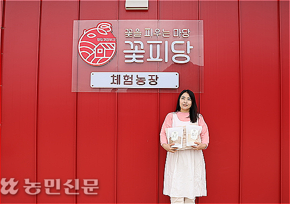 전남 영암에서 쌀귀리를 재배하는 박정윤씨가 체험농장 ‘꽃피당’ 앞에서 쌀귀리 소포장 상품을 들어 보이고 있다.