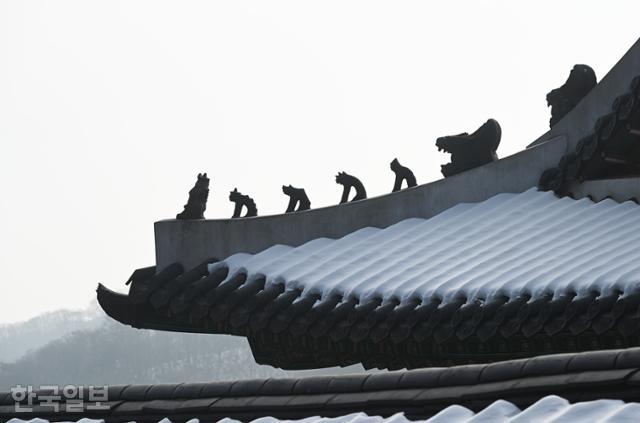 남한산성 행궁 내행전 처마 뒤로 보이는 겨울 산 능선이 적막하다.