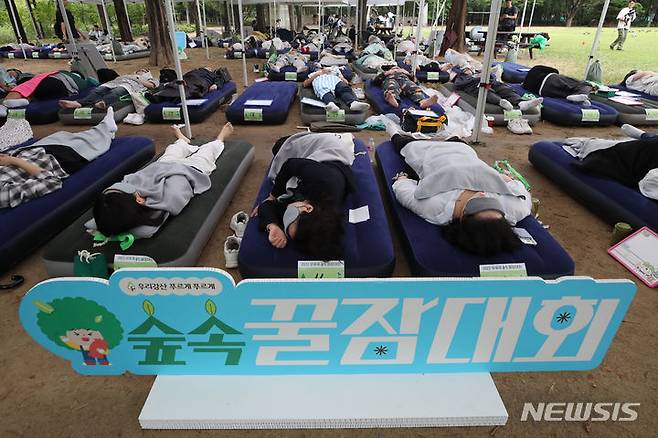 [서울=뉴시스] 권창회 기자 =  순천향대 보건행정경영학과 김선정 교수팀이 2021년 질병관리청의 지역사회건강조사에 참여한 성인 남녀 14만 1524명을 대상으로 수면시간과 삶의 만족도의 상관성을 분석한 결과 하루 7시간에서 9시간 미만 잠을 자면 삶의 만족도(주관적 건강 수준)가 가장 높아지는 것으로 나타났다. 지난해 9월 15일 오후 서울 성동구 서울숲에서 열린 2023 유한킴벌리 숲속 꿀잠대회에서 참가자들이 숙면을 취하고 있다. (해당 사진은 기사와 직접 관련이 없습니다.)  2023.09.15. kch0523@newsis.com