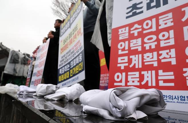 전라북도의사회가 15일 전주 완산구 전동 풍남문광장에서 집회를 열고 "의대정원 졸속 추진은 의료 붕괴를 초래한다"며 정부의 의대정원 증원 정책을 규탄하고 있다. 이들은 발언 뒤 증원 정책을 반대하고 집행부의 각오를 다지는 의미로 의사 가운을 벗는 퍼포먼스를 했다. 연합뉴스