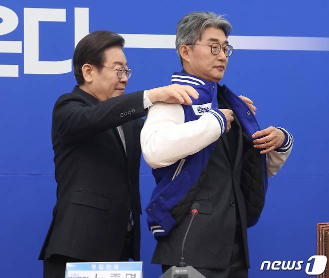 이재명 더불어민주당 대표가 2일 오전 서울 여의도 국회에서 열린 더불어민주당 13·14차 인재영입식에서 노종면 전 기자에게 민주당 옷을 선물하고 있다. 2024.2.2/뉴스1 ⓒ News1 송원영 기자