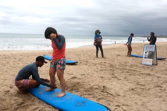 2021년 10월 6일(현지시간) 인도네시아 발리의 쿠타 해변에서 서핑 강사가 관광객들을 대상으로 파도타기 강습을 하고 있다. [사진=뉴시스]