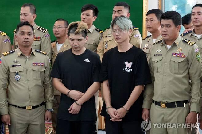 (AFP=연합뉴스) 캄보디아에서 인터넷 생방송을 통해 가짜 납치극을 벌여 체포된 2명의 대만 유튜버(가운데 검은 옷)들이 지난 15일 현지 당국의 기자회견에 참석한 모습. 2024.2.16.