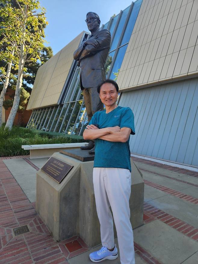 미국 대학 농구의 전설 존 우든 전 UCLA 감독(1910~2010년) 동상 앞에서 포즈를 취한 안준호 감독. 안준호 제공