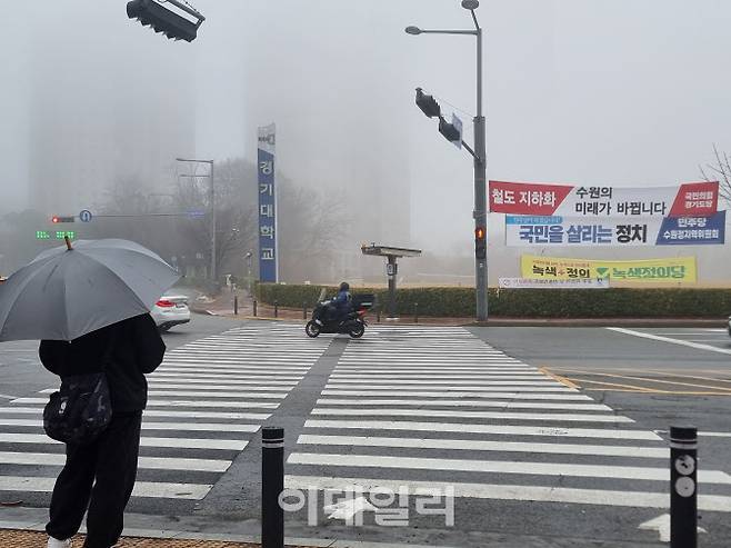 19일 오후 안개가 잔뜩 낀 수원시 영통구 경기대학교 앞 횡단보도에서 한 시민이 신호를 기다리고 있다. 황영민 기자