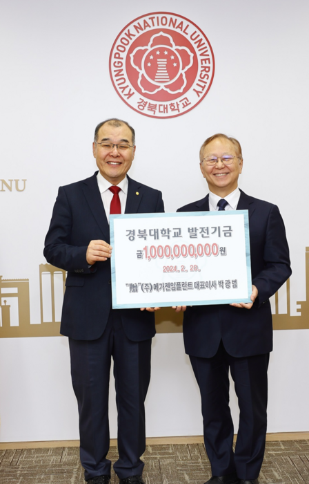 박광범 메가젠임플란트 대표(왼쪽)가 홍원화 경북대 총장에게 발전기금을 전달하고 있다.