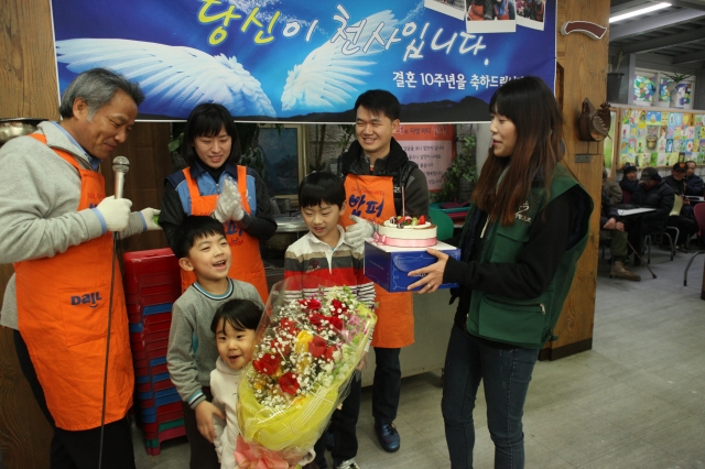김종운(뒷줄 오른쪽 두 번째) 이명신(세 번째) 부부가 2014년 서울 동대문구 밥퍼나눔운동본부에서 세 아이와 함께 결혼 10주년 축하를 받고 있다. 밥퍼나눔운동본부 제공