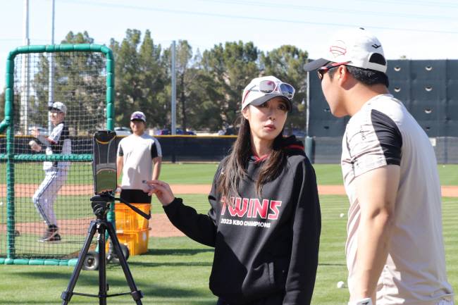 LG의 김지예 전력분석원이 21일 오전(한국시간) 미국 애리조나주 스코츠데일의 인디언스쿨파크에서 타격 훈련을 마친 문보경과 태블릿PC에 전송된 데이터를 보면서 대화를 나누고 있다.  LG 제공