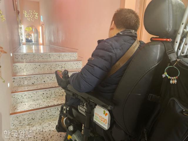 전동휠체어를 이용하는 배재현씨가 18일 CGV왕십리점 씨네&리빙관에 입장하려다 계단에 가로막혔다. 오세운 기자