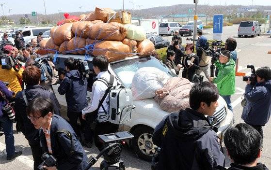 2013년 4월 승용차에 물품을 가득싣고 남측으로 입경하는 개성공단 관계자를 취재진이 둘러싸고 취재하는모습. 중앙포토