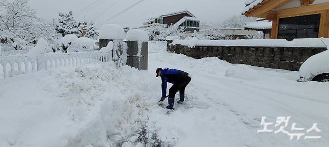 22일 강릉 성산에 60cm가 넘는 눈이 내린 가운데 이른 아침부터 눈을 치우고 있는 주민. 전영래 기자