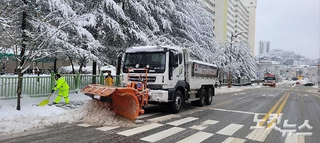 22일 오전 강릉 도심에도 20cm 안팍의 눈이 내리면서 제설작업에 나선 공무원과 제설차량. 전영래 기자