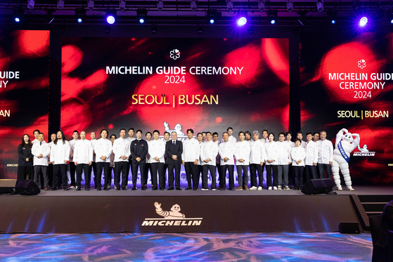 Chefs who earned this year's Michelin Guide star status take a group photo after the 2024 Michelin Guide Seoul and Busan unveiling at Busan Signiel, on Thursday. [MICHELIN GUIDE KOREA]