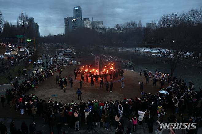 [서울=뉴시스] 김선웅 기자 = 정월대보름을 하루 앞둔 23일 서울 서초구 양재천에서 서초구 주최 정월대보름 축제가 열려 참석자들이 달집에 불을 붙이고 있다. 2024.02.23. mangusta@newsis.com