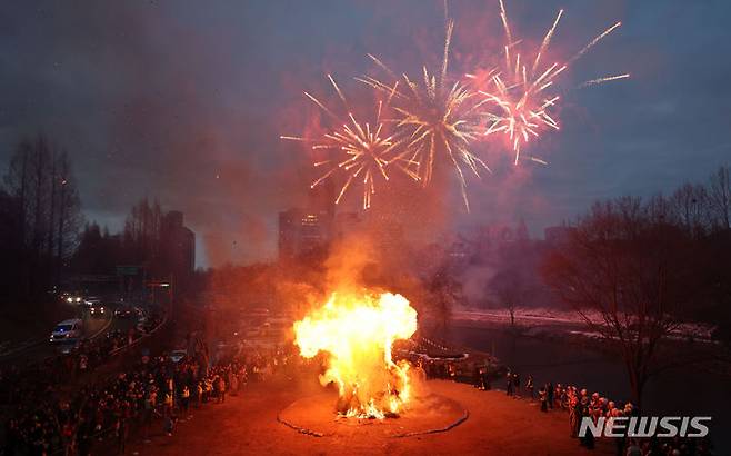 [서울=뉴시스] 김선웅 기자 = 정월대보름을 하루 앞둔 23일 서울 서초구 양재천에서 열린 서초구 주최 정월대보름 축제에서 구민들이 타오르는 달집을 보며 소원을 빌고 있다. 2024.02.23. mangusta@newsis.com