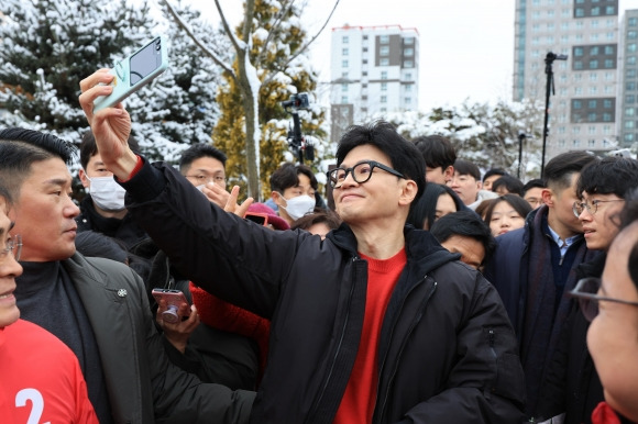 한동훈(가운데) 국민의힘 비상대책위원장이 22일 서울 구로구 오류역 문화공원해 방문해 시민들과 ‘셀카’를 찍고 있다. 연합뉴스