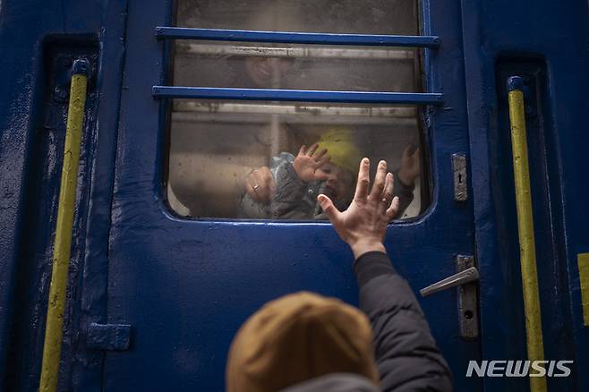 2022년 3월 우크라이나 수도 키이우에서 한 남성이 리비우행 열차에 탑승한 부인과 아들에게 작별 인사를 하는 모습./사진=뉴시스(AP)