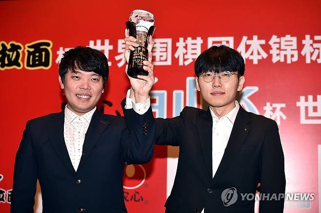 우승 트로피 들어보이는 신진서 9단 (서울=연합뉴스) 신진서(오른쪽) 9단이 23일 중국 상하이에서 열린 제25회 농심신라면배 세계바둑최강전 3라운드 최종 14국에서 중국의 마지막 주자 구쯔하오 9단에게 불계승 후 열린 시상식에서 홍민표 감독과 함께 트로피를 들어 보이고 있다. 2024.2.23 [한국기원 제공. 재판매 및 DB 금지] photo@yna.co.kr