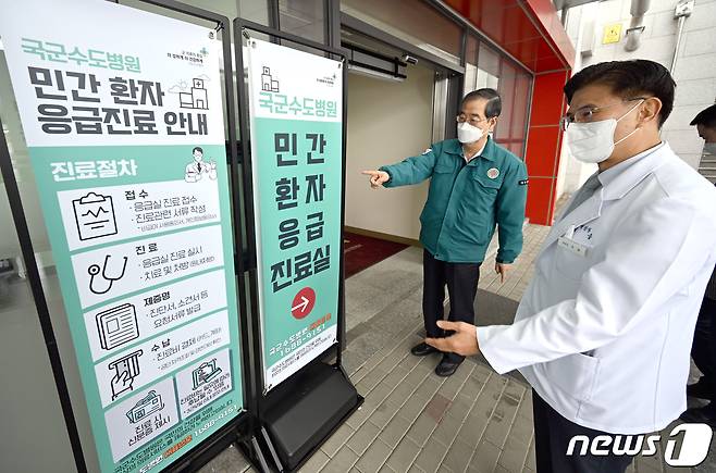 전공의 파업이 이어지는 25일 경기 성남시 국군수도병원 국군외상센터를 찾은 한덕수 국무총리가 석웅 국군수도병원장의 소개로 민간환자 응급진료 안내판을 보고 있다. 2024.2.25/뉴스1 ⓒ News1 청사사진기자단