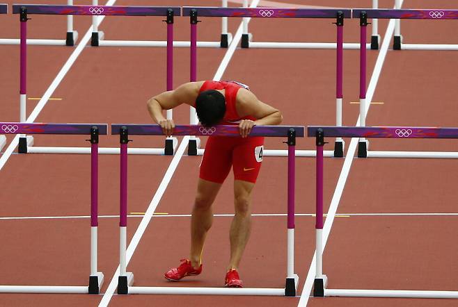 중국 육상선수 류샹이 2012년 8월7일 런던올림픽 110m 허들 경기에서 허들에 걸려 넘어져 예선 탈락한 다음 허탈해하며 허들에 입맞춤하고 있다. REUTERS 연합뉴스