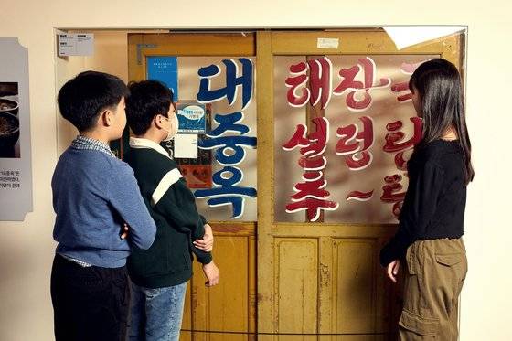 왕십리에서 60여 년간 영업하다 재개발로 역삼동으로 이전 후 철거한 해장국집 대중옥의 미닫이문을 살펴보고 있는 소중 학생기자단.