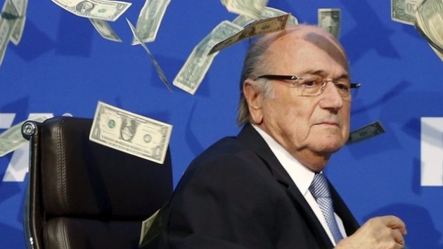 2015년 7월 FIFA 집행위원회 자리에서 영국의 한 코미디언이 제프 블라터 당시 회장에게 가짜 돈다발을 뿌리며 FIFA의 배금주의를 비판한 퍼포먼스 당시의 사진 <출처=BBC>
