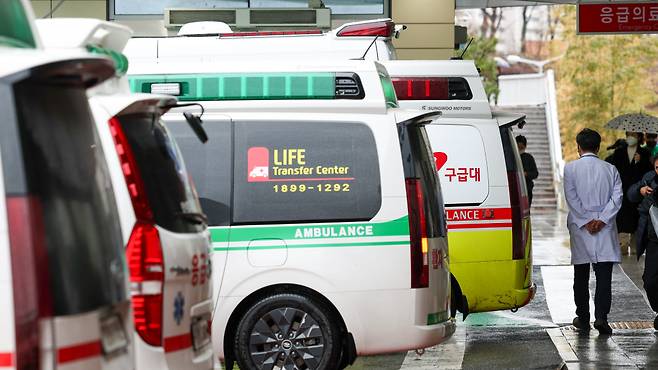 정부의 의대 증원에 반발한 전공의 집단 이탈로 인해 의료공백이 우려되고 있는 21일 오후 서울 시내 한 대학병원에서 의료진이 줄지어 선 구급차를 지나가고 있다./사진=뉴시스
