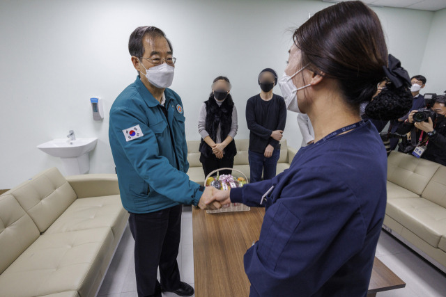 한덕수(왼쪽) 국무총리가 25일 경기도 성남 국군수도병원에서 이 병원으로 중환자를 바로 전원 조치한 간호사를 격려하고 있다. 연합뉴스