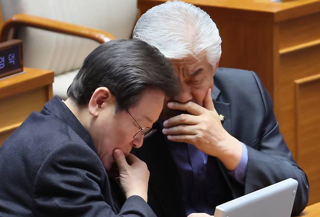 이재명 더불어민주당 대표가 23일 국회에서 열린 본회의 대정부질문에서 울산 북구 후보 무공천 관련 항의 표시를 한 이상헌 의원을 찾아가 대화하고 있다. [연합]