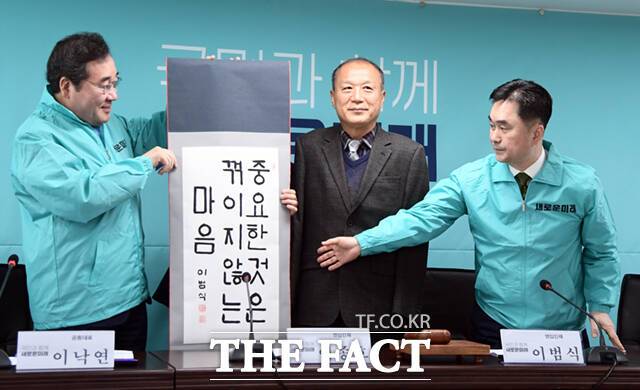 이낙연 새로운미래 대표 겸 인재위원장(왼쪽)이 28일 오전 서울 여의도 새로운미래 중앙당사에서 영입 인재로 당에 합류한 이범식 영남이공대 겸임 교수(가운데)가 쓴 문구를 공개하고 있다. /이새롬 기자