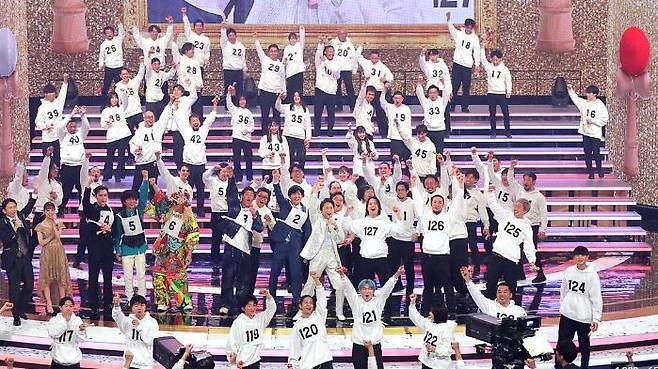 지난해 12월 31일 일본 NHK 홍백가합전에서 128명이 출전한 '켄다마 챌린지'가 끝나고 참가자들이 기네스북 등재를 자축하고 있다. 이날 챌린지는 후에 '16번 남성'이 실패했던 것이 뒤늦게 확인돼 물거품이 됐다. 사진 속 맨 오른쪽 '16번 남성'이 다소 경직된 모습으로 서 있다. /일본 스포츠호치