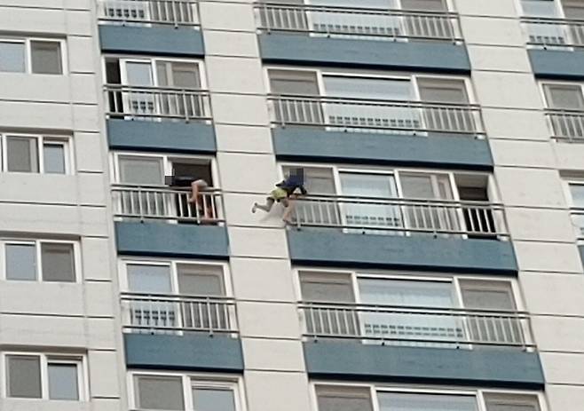 아파트 외벽에서 난간을 붙잡고 이동 중인 아이들. /온라인 커뮤니티