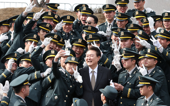 President Yoon Suk Yeol, center, smiles as he poses for photographs with reserve officers at a commissioning ceremony at the Army Cadet Military School in Goesan, North Chungcheong, on Wednesday. [JOINT PRESS CORPS]