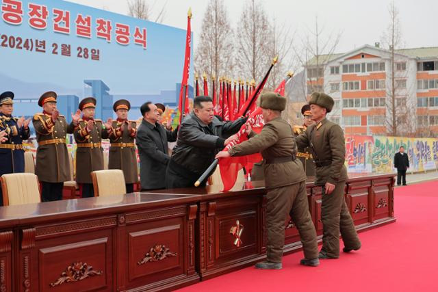 김정은 북한 국무위원장이 지방발전 20X10 정책에 동원되기 위해 조직된 조선인민군 제124연대에 부대 깃발을 수여하고 있다. 평양=노동신문 뉴스1