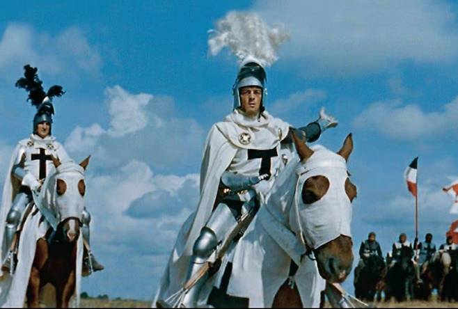 1960년대 영화 ‘튜튼기사단(Knights of the Teutonic Order)’의 한 장면. 튜튼기사단은 검은색 십자가가 그려진 흰색 옷과 가운을 입었다. 그에 반해 비참한 최후를 맞았고 음모론에 등장해서 유명해진 성전(템플)기사단은 흰색 상의에 빨간 십자가를 부착했다. 영화 캡처