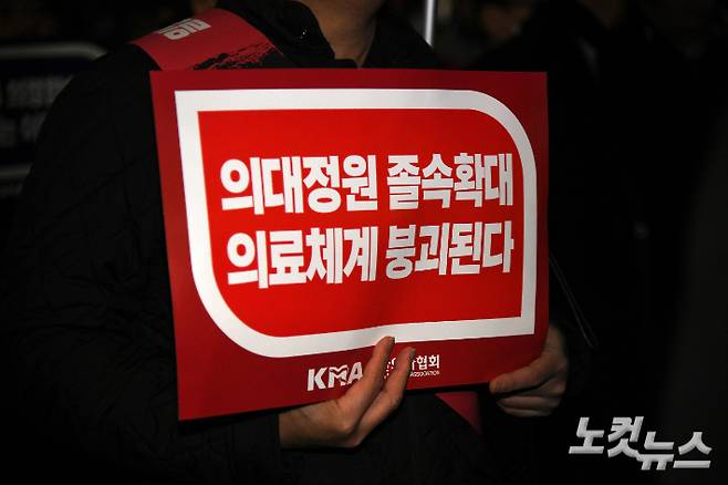 대한의사협회 산하 서울시의사회 회원들이 지난달 15일 용산 대통령실 앞에서 열린 정부의 의대 증원 방침 반대 궐기대회에서 피켓을 들고 있다. 박종민 기자