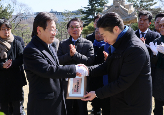 이재명 더불어민주당 대표가 1일 서울 효창공원 내 백범 김구 선생 묘역을 참배한 뒤 총선 영입 인재인 김용만 대한민국임시정부기념사업회 이사로부터 김구 선생의 휘호를 전달받고 있다.<연합뉴스>