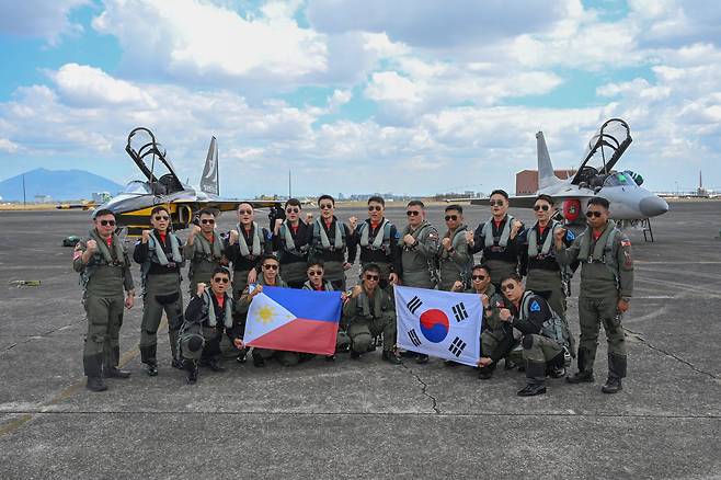 공군 블랙이글스의 T-50B와 필리핀 공군의 FA-50PH 조종사들이 3일 필리핀 클락 공군기지에서 한-필리핀 수교 75주년을 축하하는 우정비행을 마친 뒤 기념 촬영하고 있다. 사진 공군