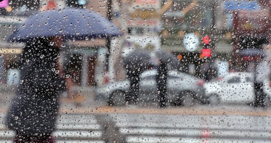 지난달 29일 부산 동구 부산역 앞에서 우산을 쓴 시민들이 횡단보도 신호를 기다리고 있다. 뉴시스