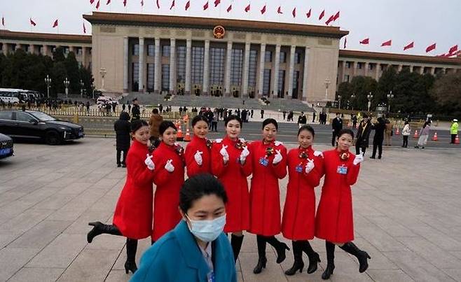 전국인민대표대회(전국인대) 개막을 하루 앞둔 4일 중국 베이징 인민대회당 앞에서 안내원들이 기념 촬영하고 있다. ⓒ AP/뉴시스