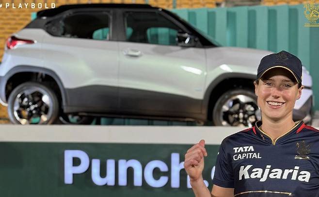 로열 챌린저스 방갈로르의 엘리스 페리가 유리창이 깨진 경품용 차 앞에서 포즈를 취했다. 사진출처=인스태그램