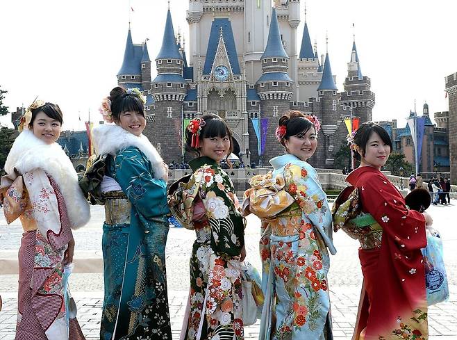 기모노를 입은 일본 여성들이 일본 도쿄의 테마파크인 디즈니랜드를 이용하는 모습/AFP연합뉴스