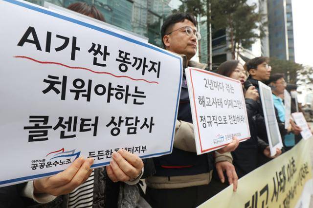 지난달 14일 오전 서울 영등포구 KB국민은행 신관 앞에서 열린 민주노총 공공운수노조 콜센터지부의 '국민은행 콜센터 상담사 정규직 전환 촉구 기자회견'에서 참석자들이 손팻말을 들고 있다. 연합뉴스