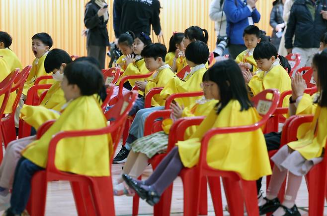 [서울=뉴시스] 고승민 기자 = 4일 서울 광진구 성자초등학교에서 열린 입학식에서 노란 가운을 입은 신입생들이 박수를 치고 있다.