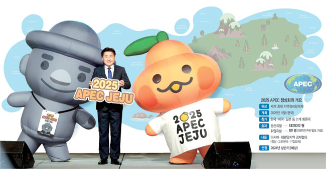 오영훈 제주지사가 2025 APEC 제주유치 홍보대사로 위촉된 고르방(왼쪽), 부라봉 캐릭터와 함께 사진 촬영을 하고 있다.  제주도청 제공, 그래픽 = 하안송 기자
