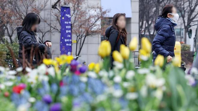 8일 아침 기온이 전국 대부분 지역에서 영하로 떨어지며 막바지 '꽃샘 추위'가 찾아온다. 사진은 지난달 29일 오전 서울 성동구 왕십리광장 화단 너머로 겨울 외투를 챙겨입은 시민들이 오가고 있는 모습./뉴스1