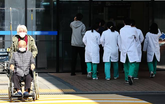 정부가 의료 현장을 집단 이탈한 전공의 7000여 명에 대한 면허정지 절차에 돌입한 4일 서울 시내의 한 대학병원에서 환자 옆으로 의료진들이 이동하고 있다. /뉴시스