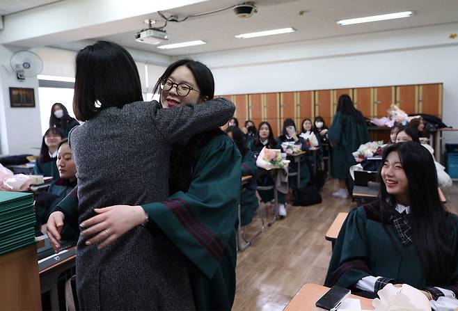 8일 오전 서울 중구 이화여고에서 열린 2022학년도 졸업식을 마친 졸업생들이 교실에서 담임선생님에게 졸업장을 전달받으며 포옹하고 있다. /연합뉴스