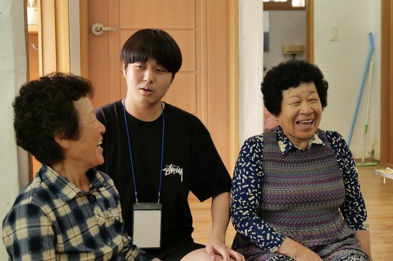 경상국립대 한 학생이 한산도 대고포마을 할머니들과 대화하고 있다. '할매꽃 피는 마을'로 불리는 이 대학은 65세 이상 주민이 80%가 넘는 대고포마을을 되살리기 위해 지난해 꽃밭 문패 만들기 등을 추진했다. 사진 경상국립대