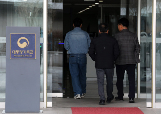 Officials enter the Presidential Archives in Sejong City on Sunday. Prosecutors launched a raid on the presidential archives on Sunday in connection with the Moon Jae-in administration\'s alleged interference in the Ulsan mayoral election. Yonhap News Agency